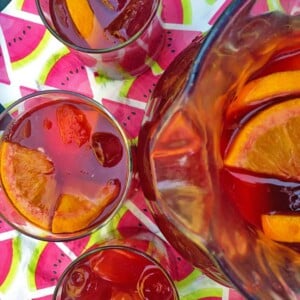 Pitcher of sangria with three glasses.