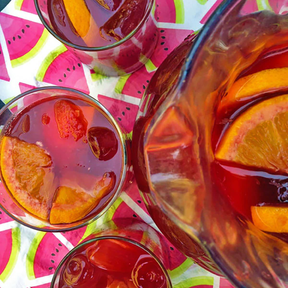 Pitcher of red sangria with three glasses.