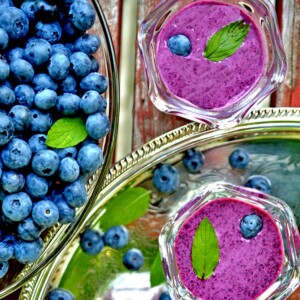 Bowl of fresh blueberries and two servings of bluebery soup