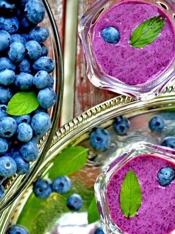 Bowl of fresh blueberries and two servings of bluebery soup