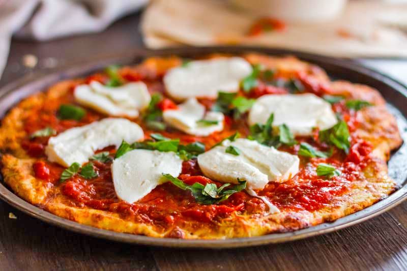 A pizza topped with fresh cheese and basil