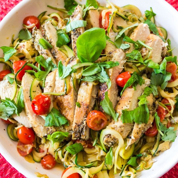 Bowl of chicken covered with shredded basil.