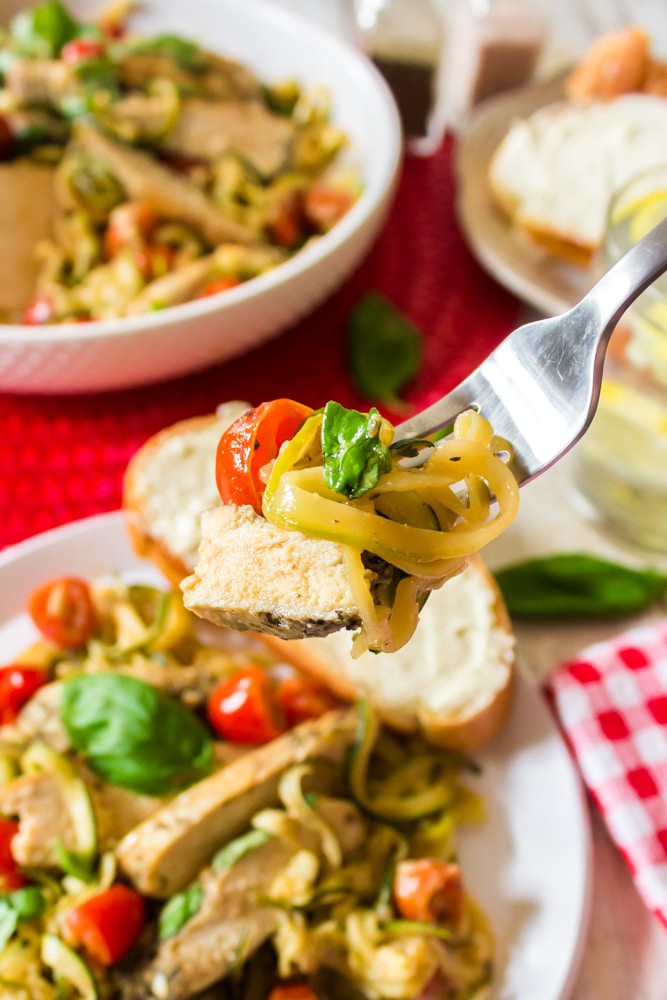Eating a chicken and zucchini pasta dish A plate of food on a table, with Salad
