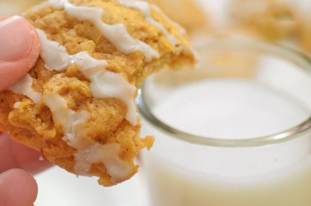 A soft pumpkin cookie with vanilla glaze that being dunked in milk.