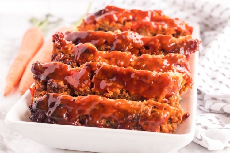 Plate of meatloaf with whole carrots on the side.