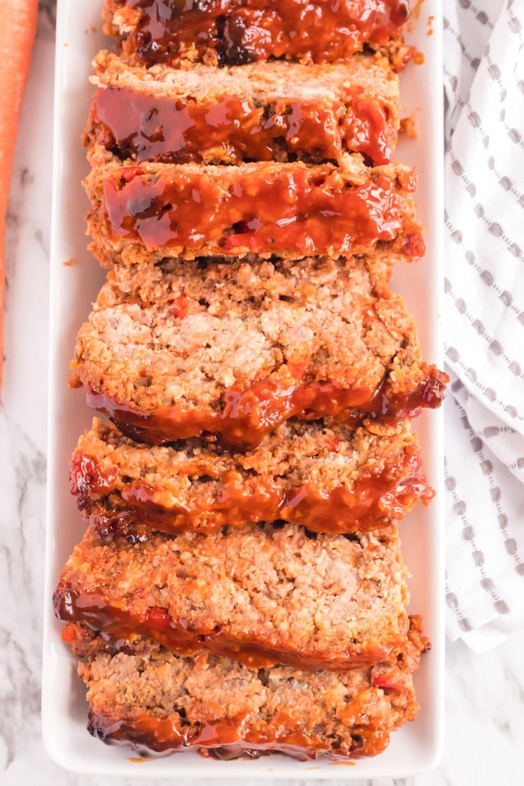 Sercing platter of whole meatloaf cut into slices.