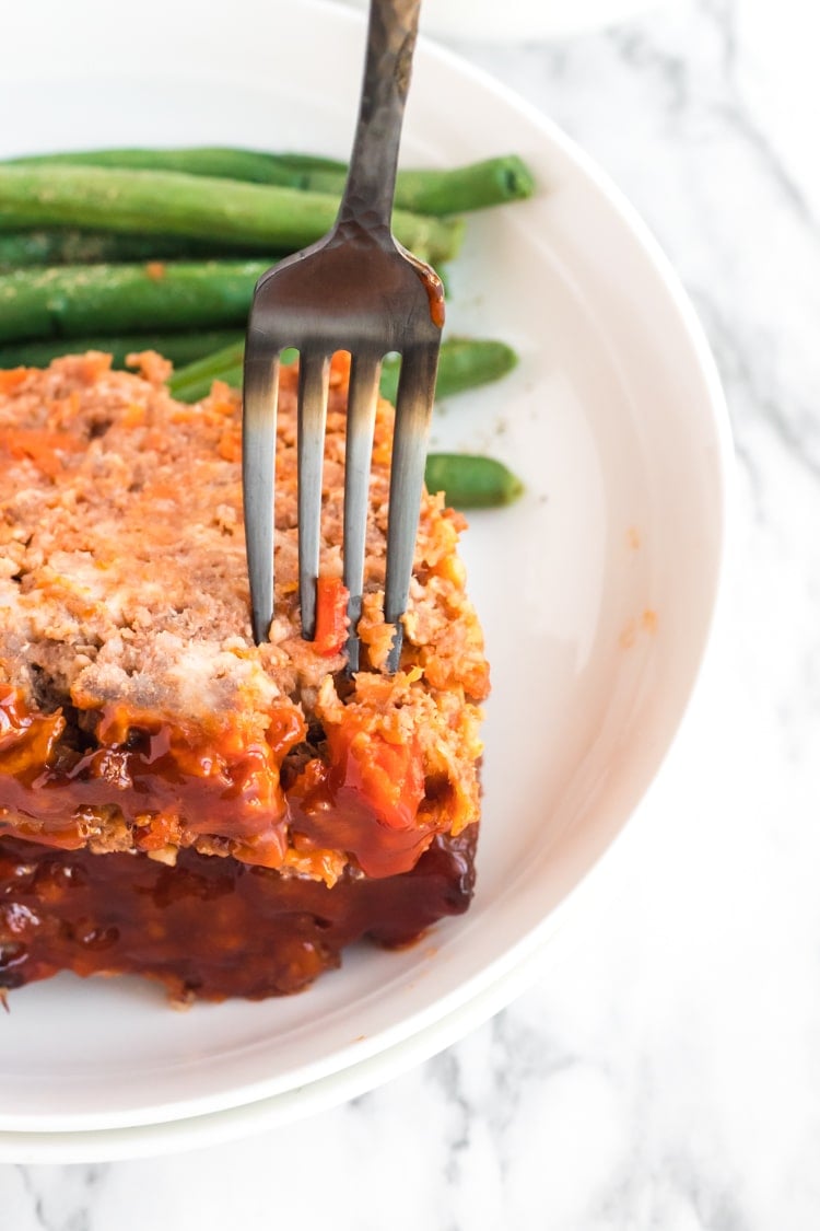 A close up of a plate of food with a fork, with Meatloaf and Platter