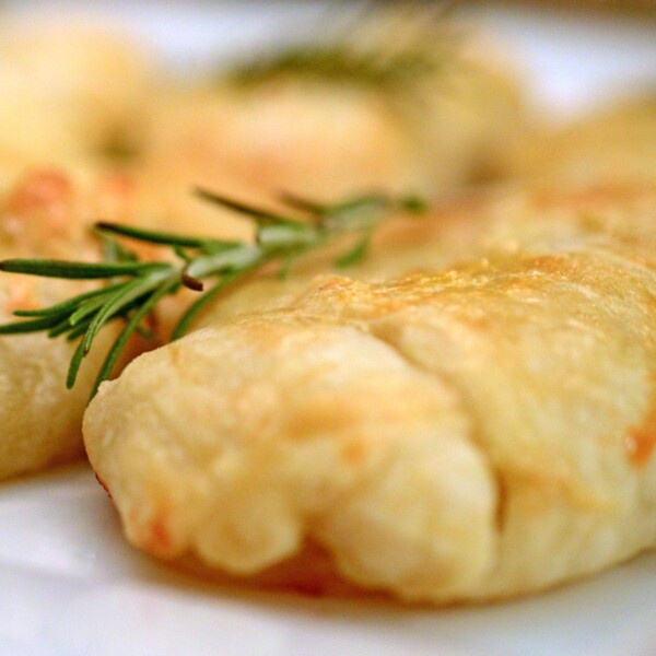 Some food on a plate with rosemary spirg