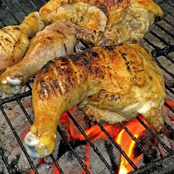 Chickn leg quarter on a hot grill.