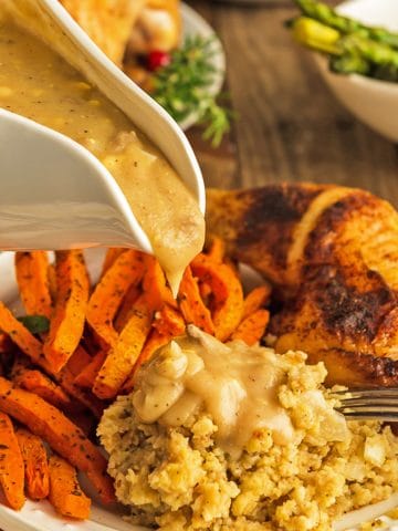 Gravy bowl over chicken dressing and carrots.