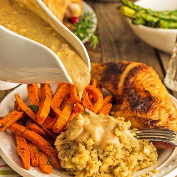 Gravy bowl over chicken dressing and carrots.