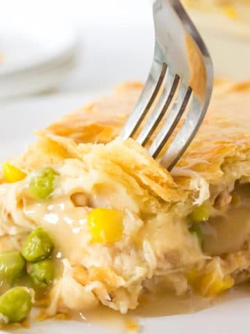 A fork digging into a slice of turkey pot pie.