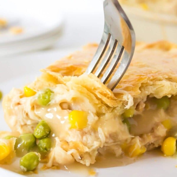 A fork digging into a slice of turkey pot pie.
