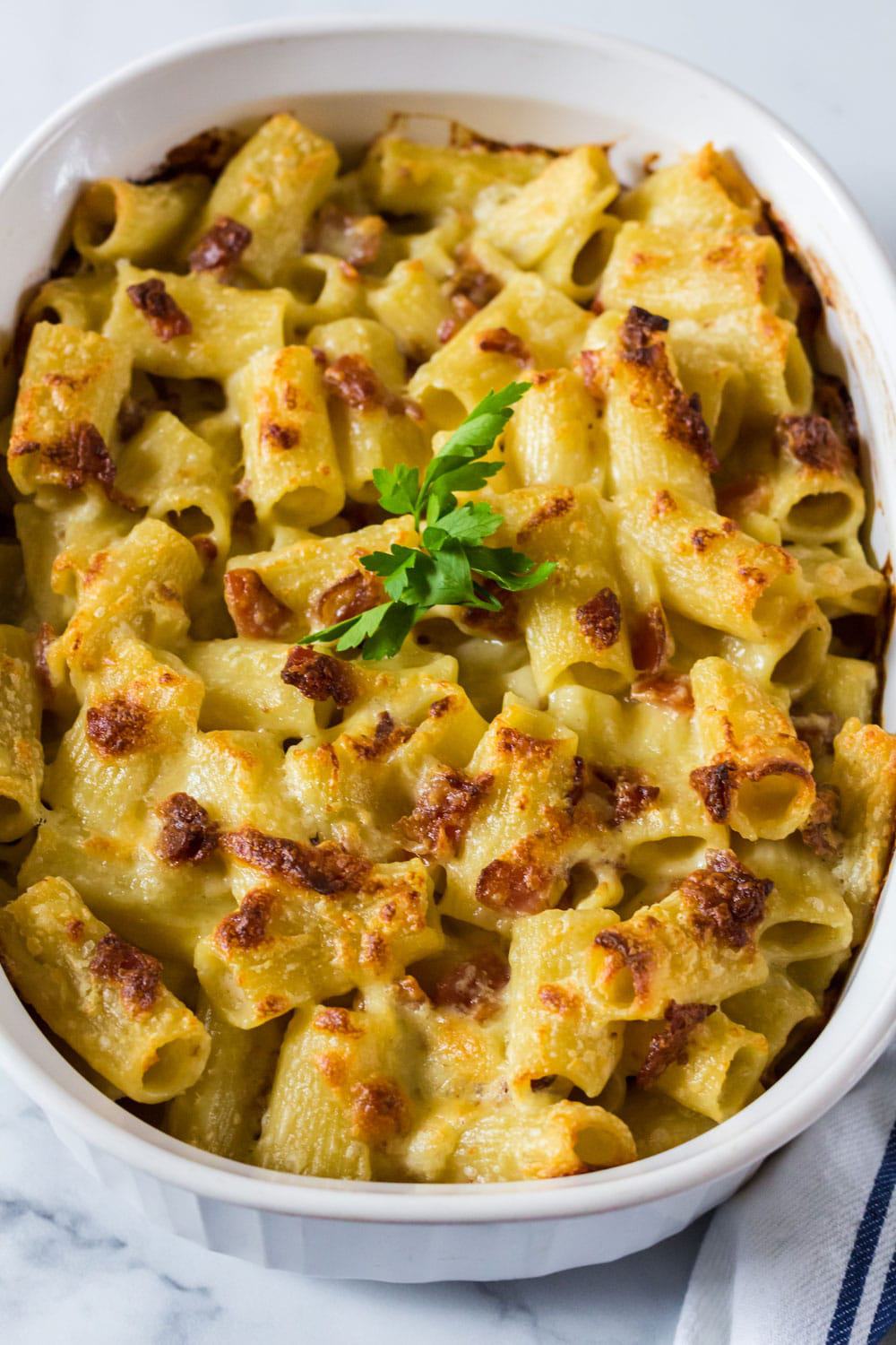 Baked macaroni and cheese in a 2-quart baking dish with parsley garnish.