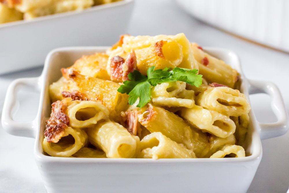 A close up of a plate of food, with Cheese and pasta