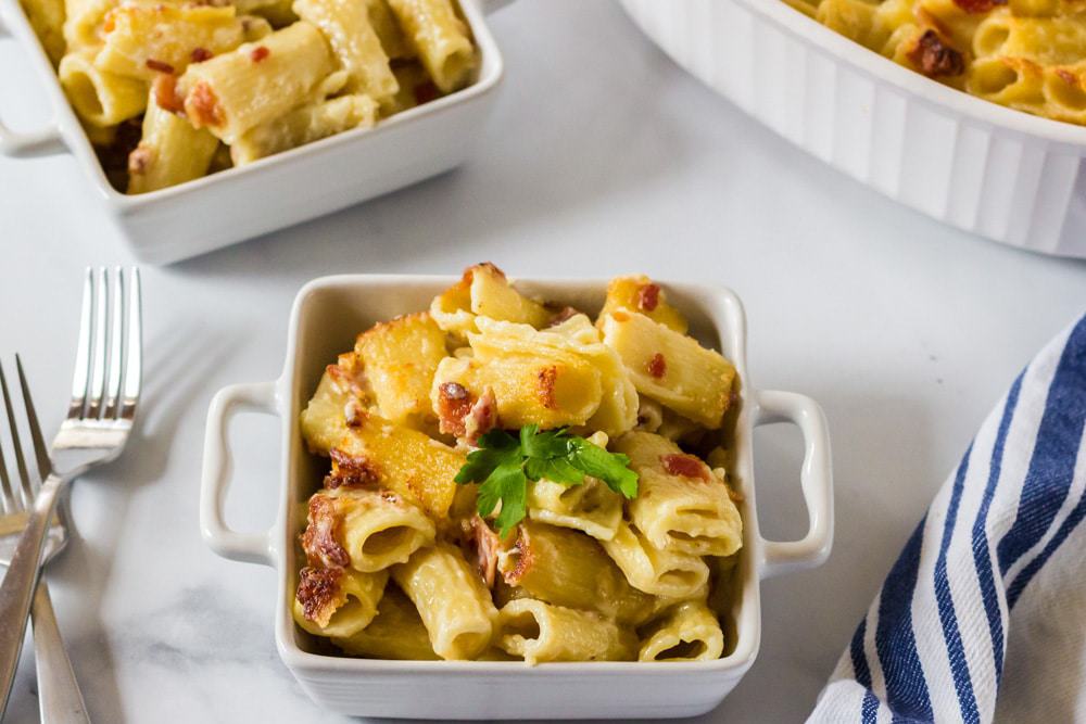 A tray of food on a plate, with Cheese pasta