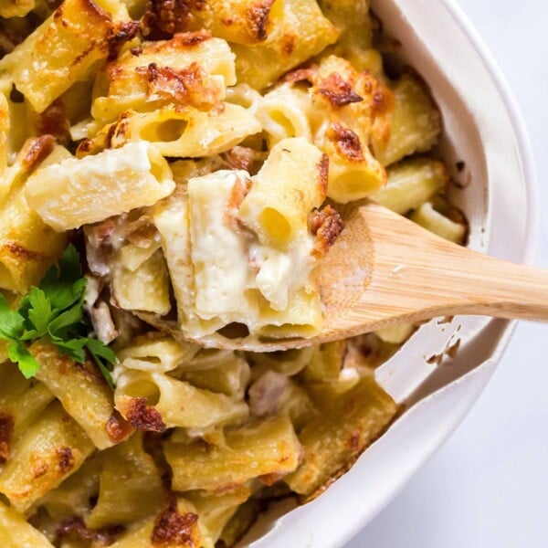 Baking dish of mac and cheese with a wooden spoon in it.