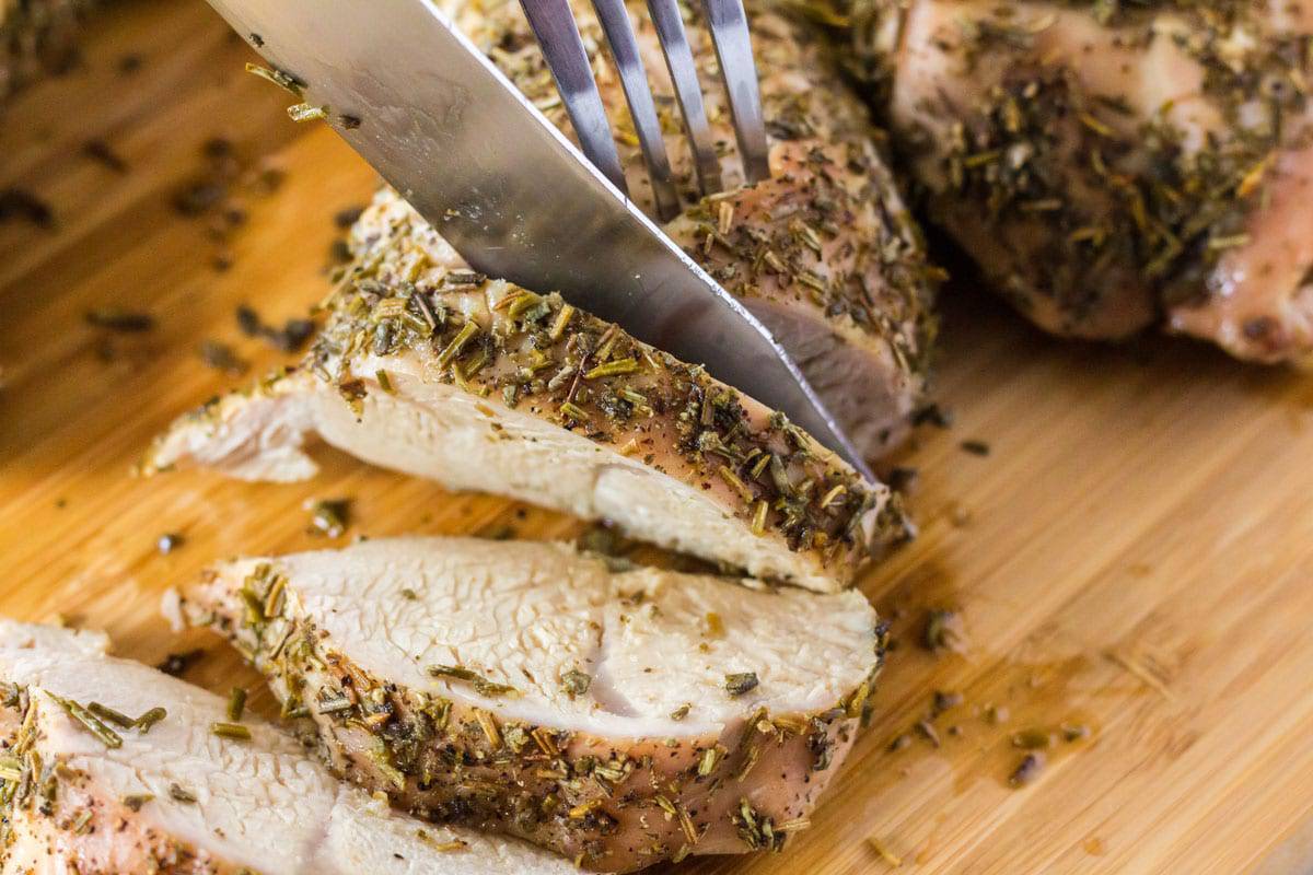 Cutting a turkey tenderloin with a knife and fork.