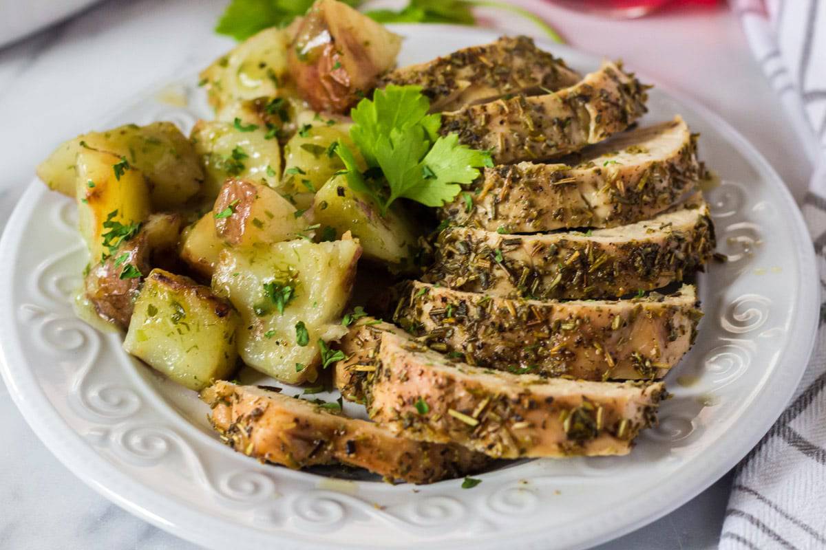 Serving platter to herb-roasted turkey tenderloin and potatoes.