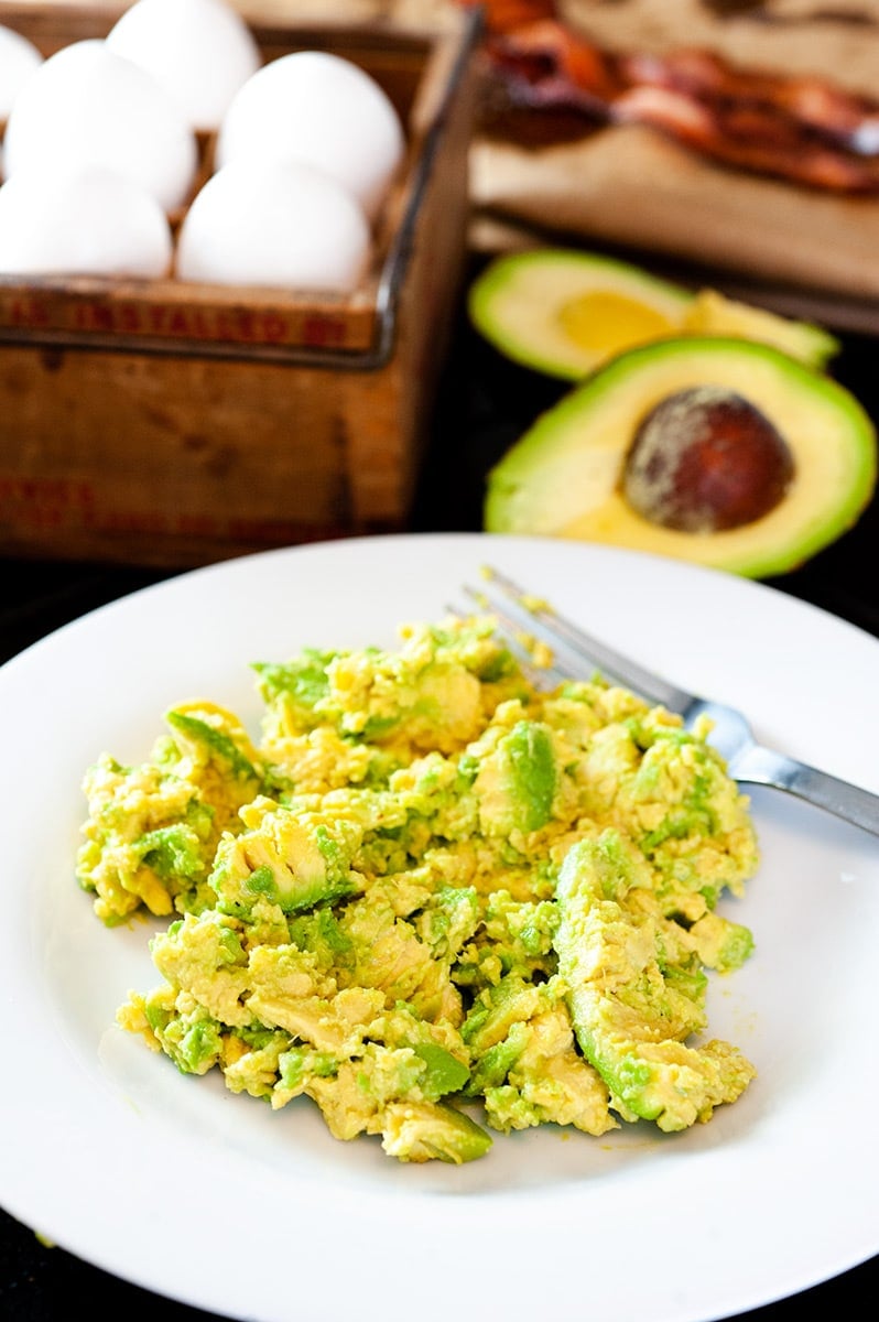 Mashed avocado on a white plate.