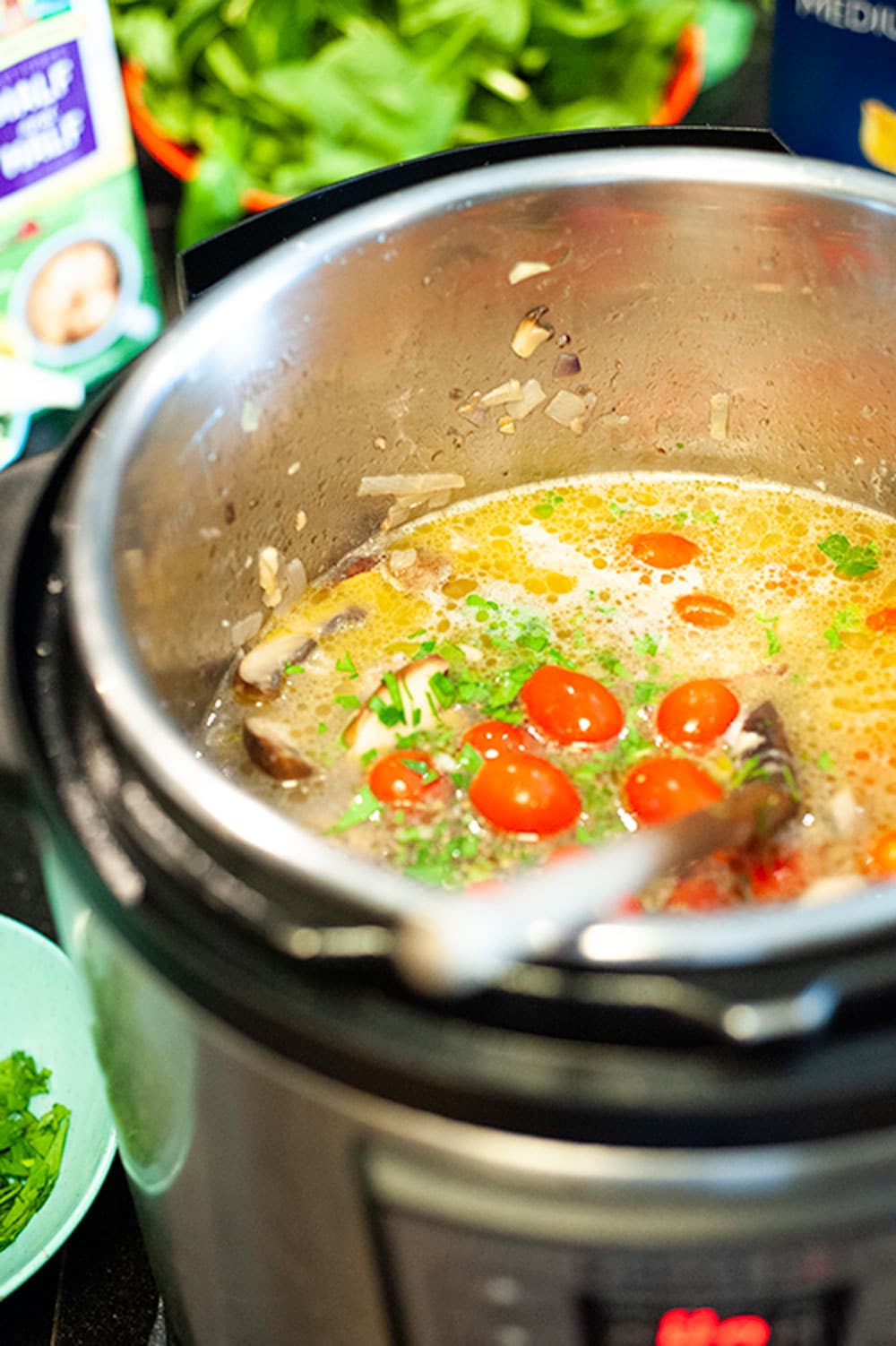 Instant pot with broth and tomatoes.