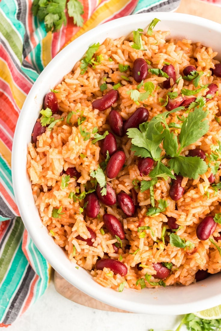 Large white bowl with Spanish rice and beans and garnished with cilantro.