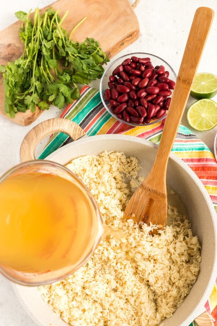 Addiong broth to a bowl of rice.