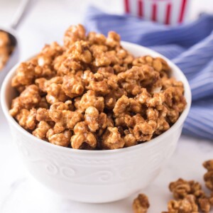 Ready to eat, heaping white bowl of caramel popcorn.