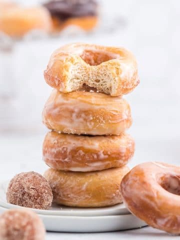 Stack of raised donuts on a white plate