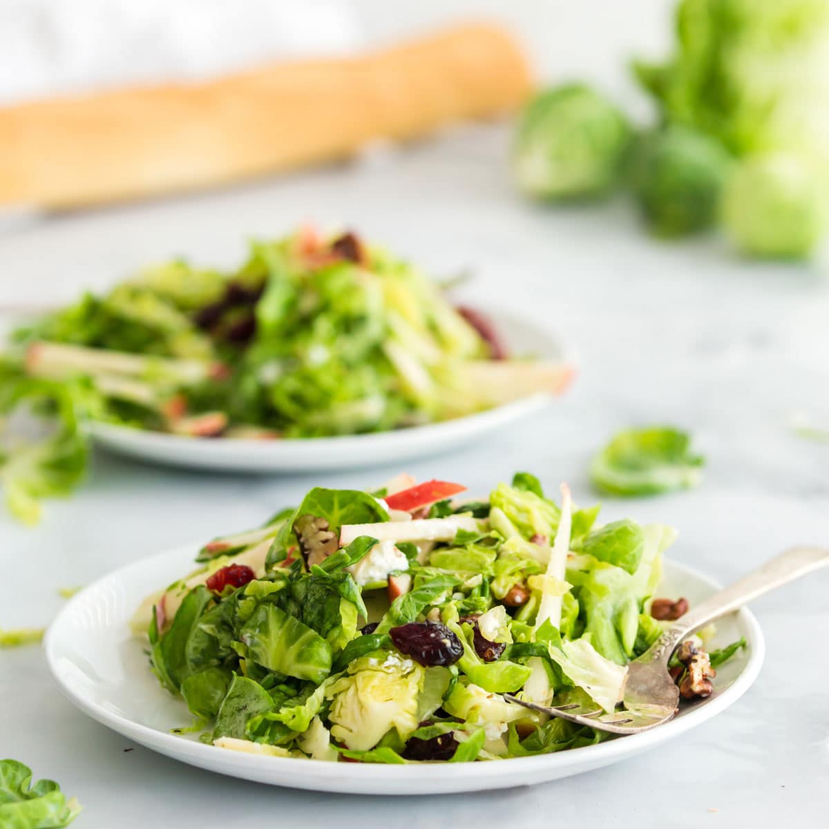 Two bowls of salad with Brussels sprouts