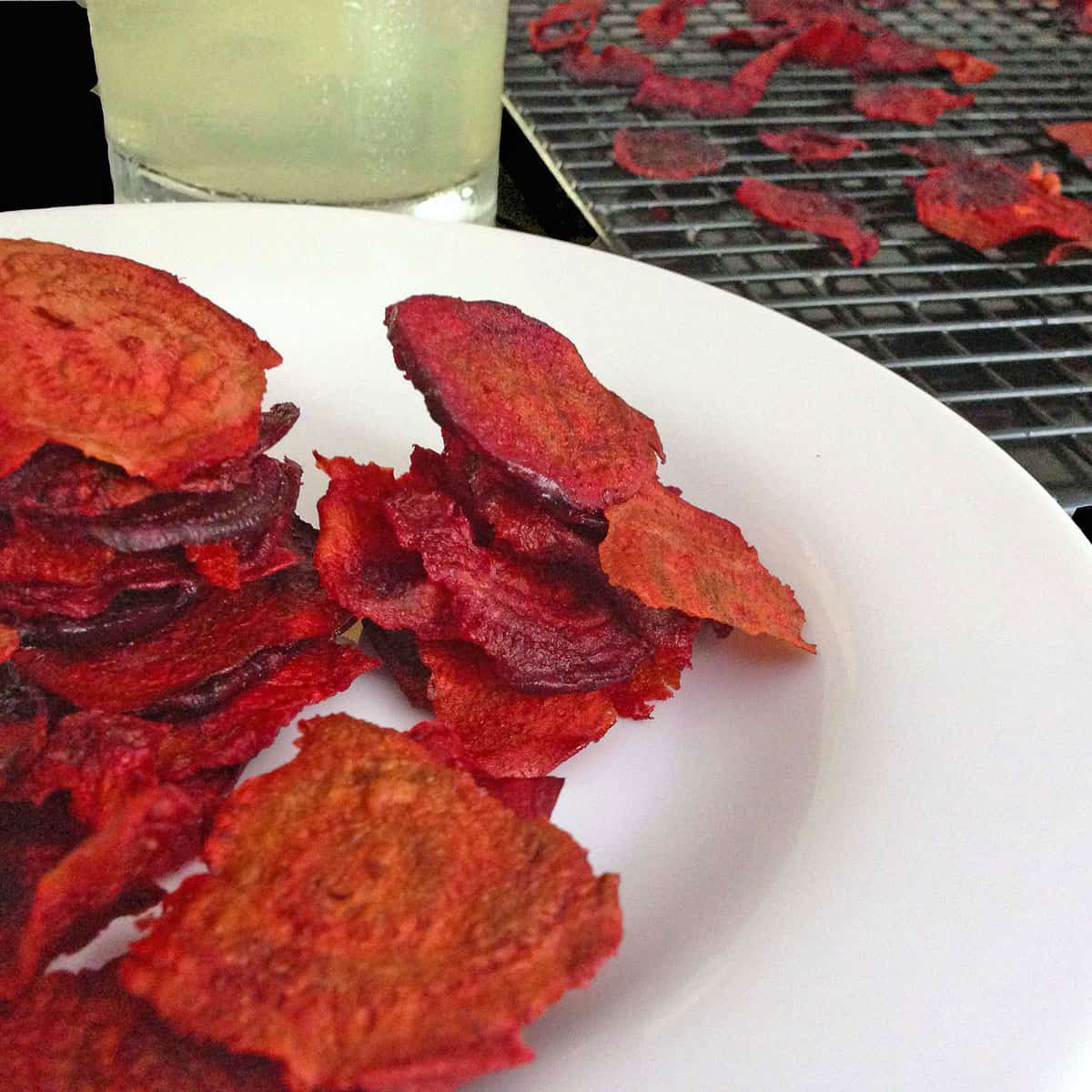 A plate of beet chips and a glass of lemonade.