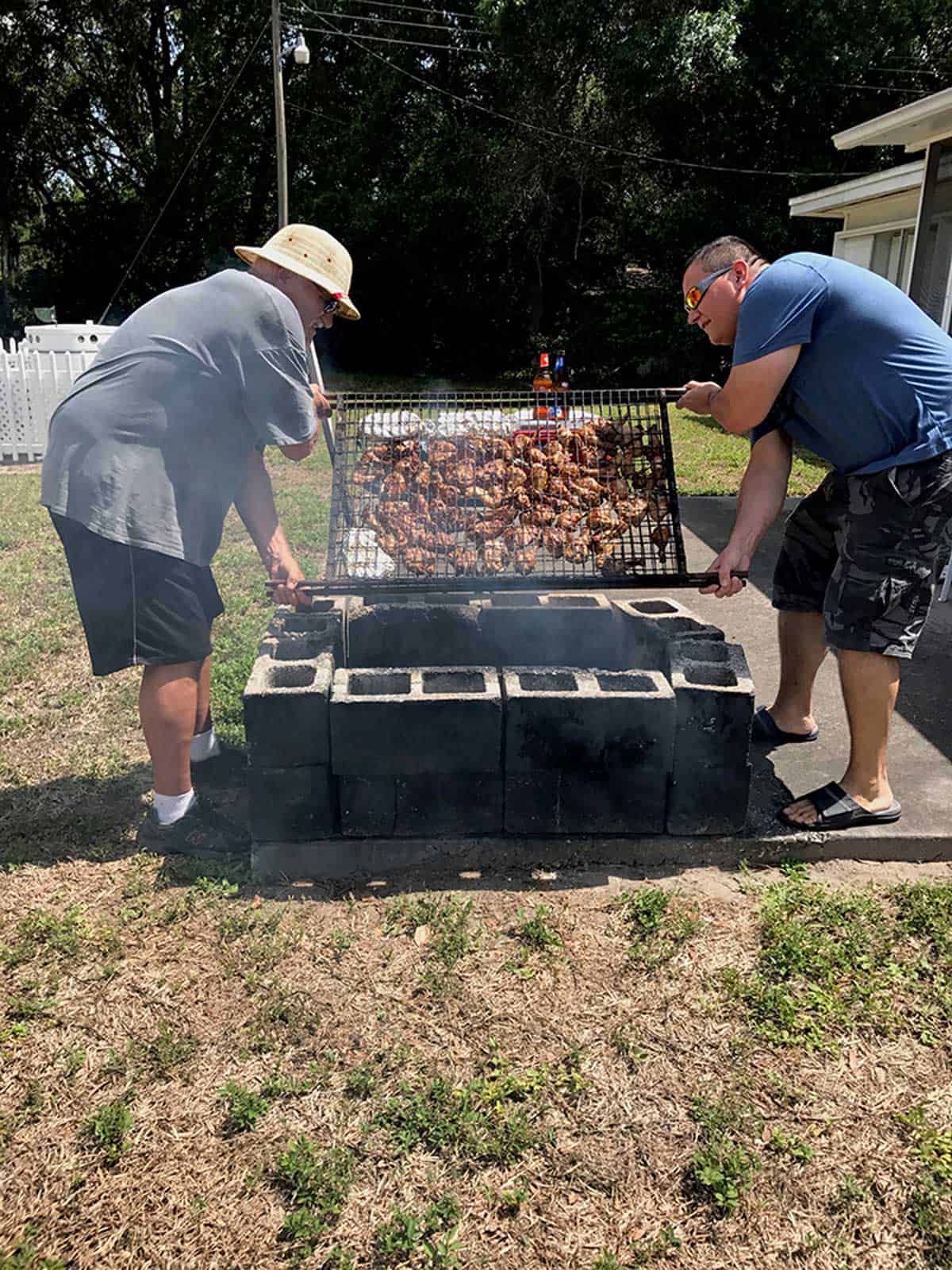 Two men grilling chicken