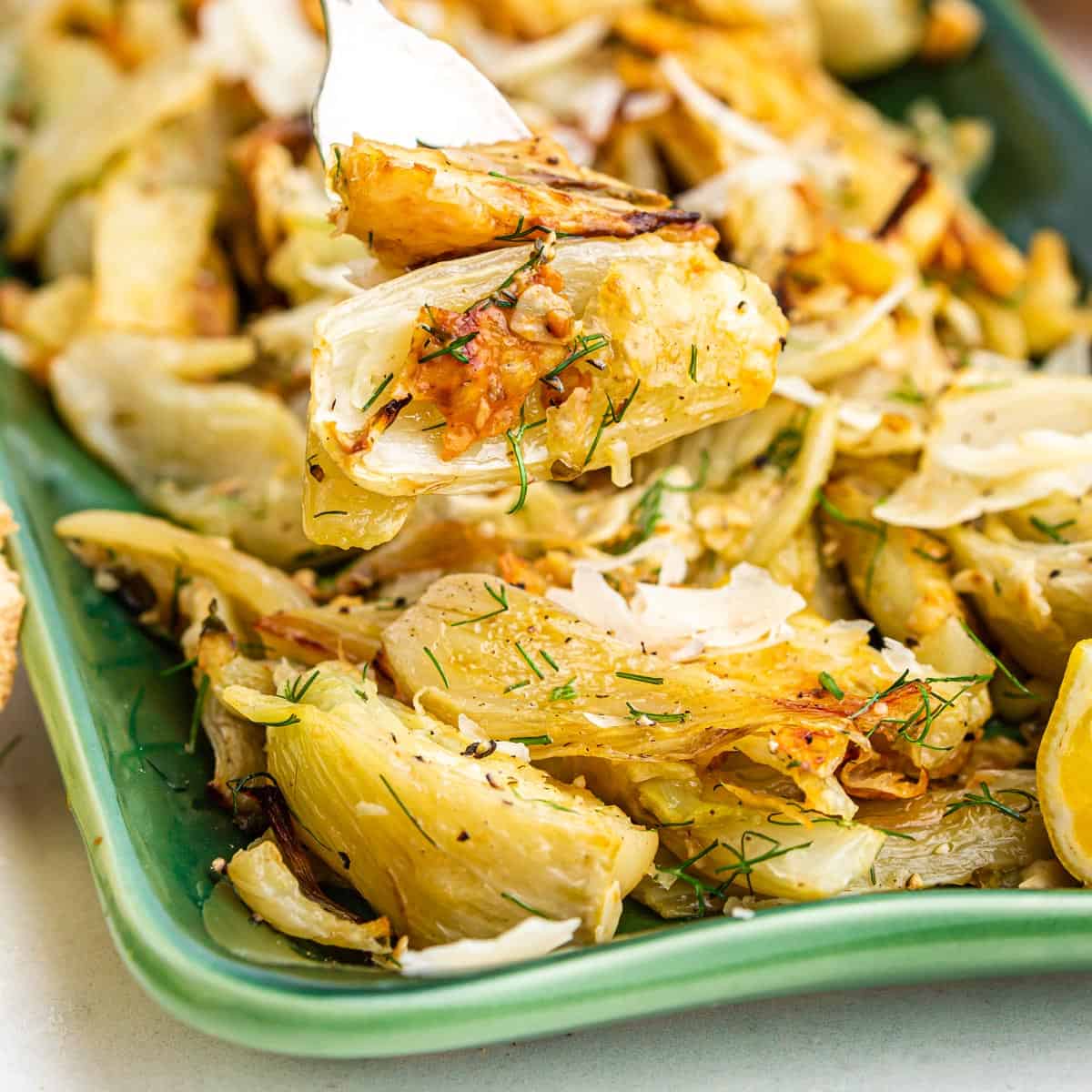 Serving dish of roasted fennel with a fork.