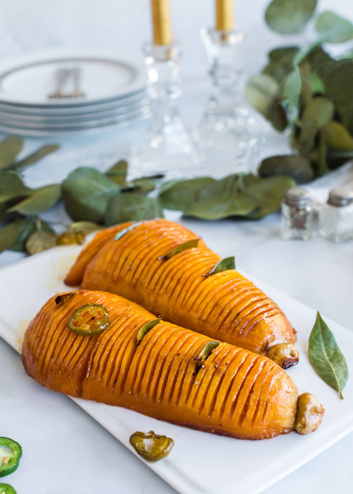 Two hasselback butternut squash on a serving plate