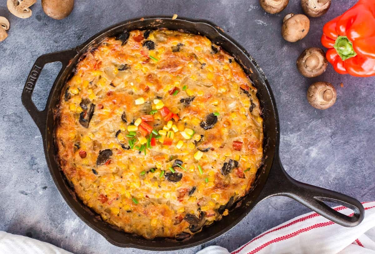Scalloped corn casserole in a skillet Skillet with a casserole in it.