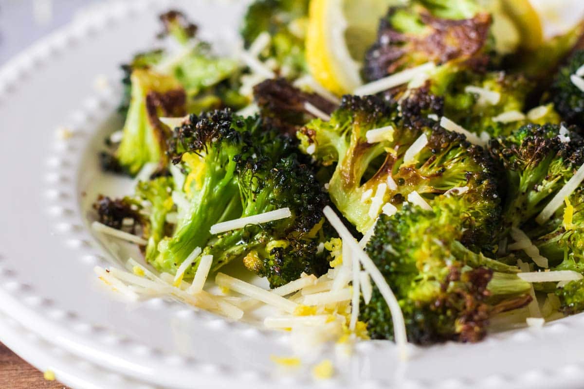 Plate of roasted broccoli with cheese A plate or roasted broccoli and cheese