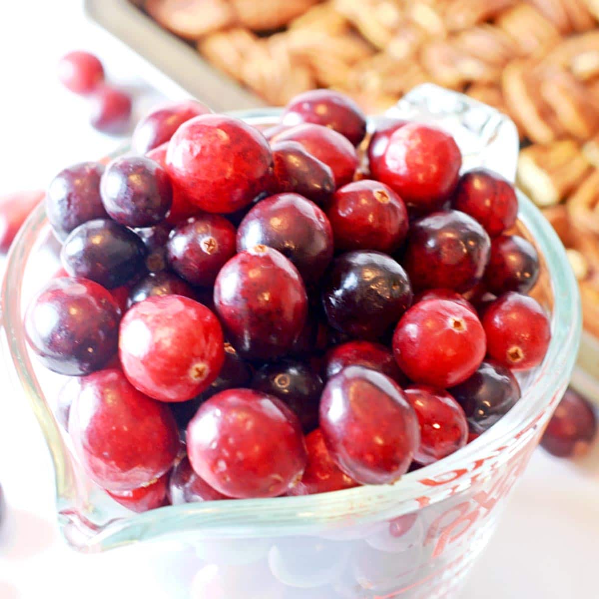 A large measuring cup of fresh cranberries.