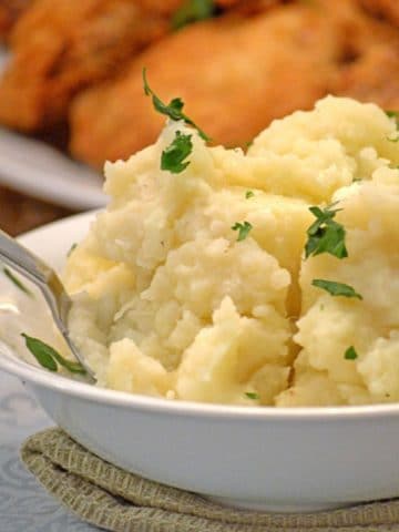 A bowl of mashed potatoes on a table.