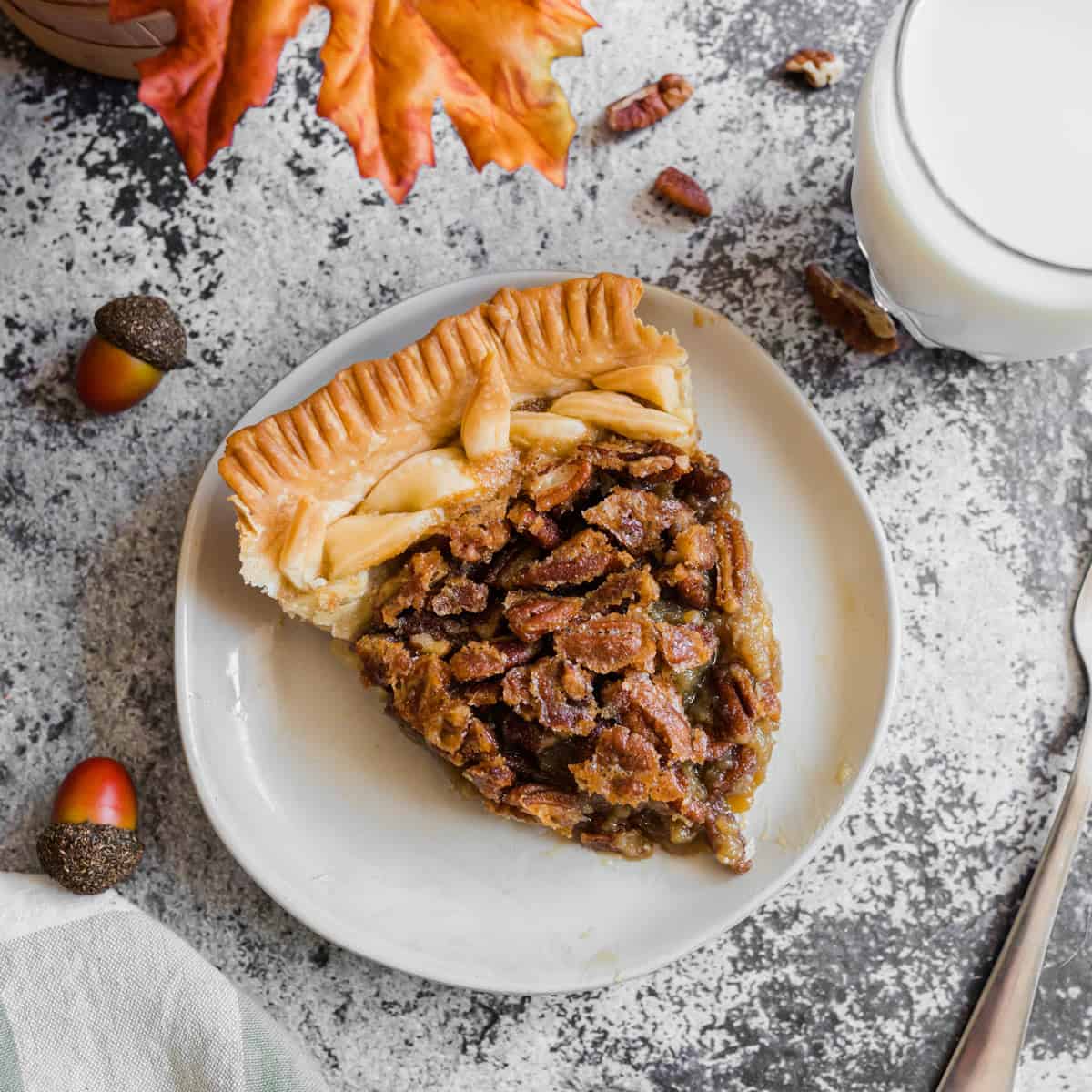A piece of homemade pecan pie on a plate. A slice of homemade pecan pie on a plate.