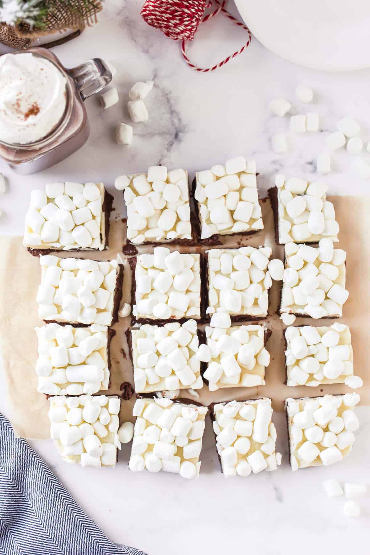 A board of square desserts covered with mini marshmallows.