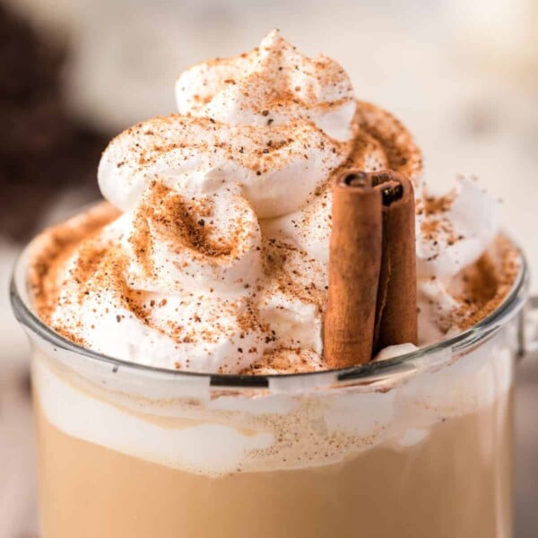 Closeup of a homemade latte topped with whipped cream and cinnamon
