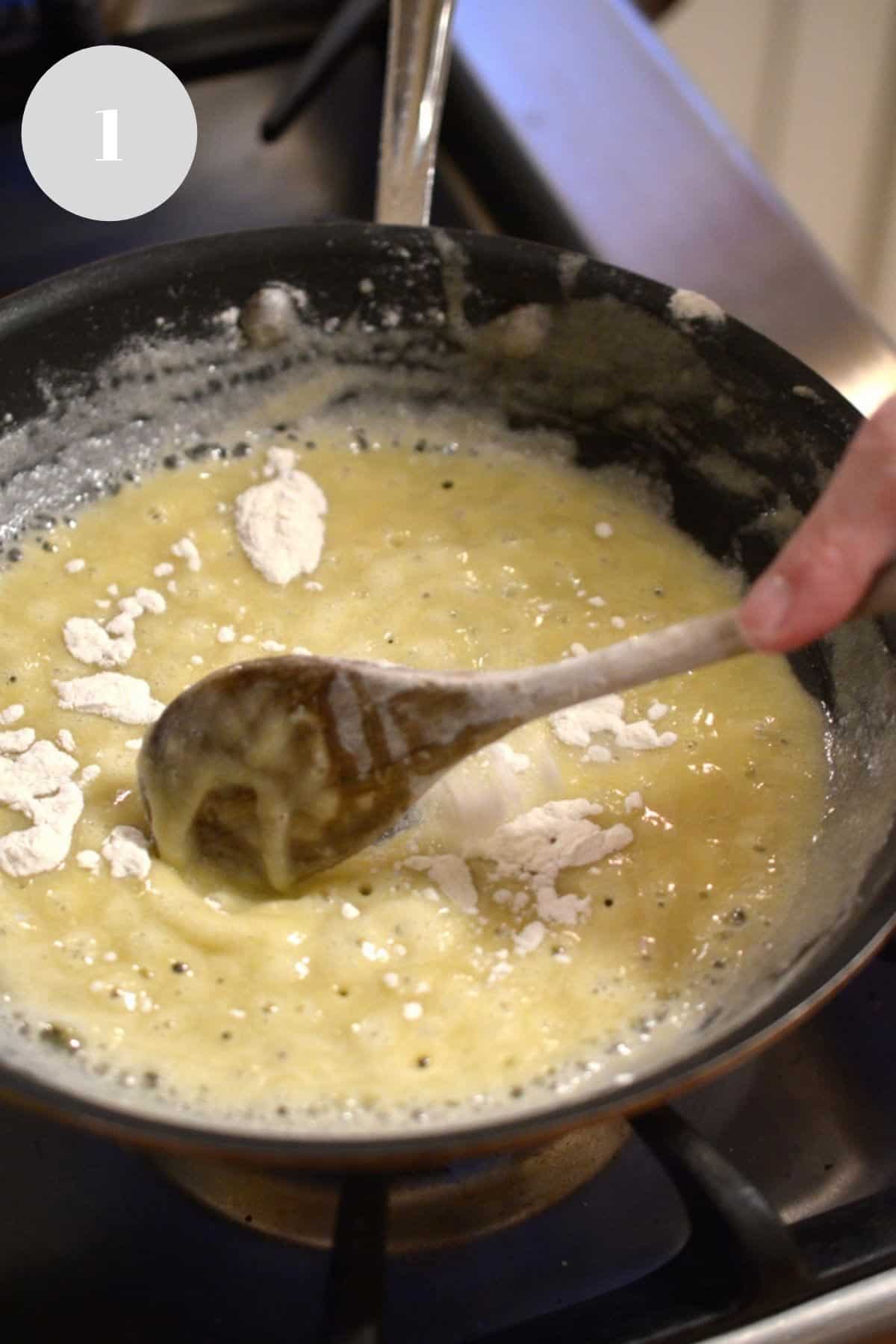 Combining butter and flour to make a roux. Stirring flour and fat in a pan with a wooden spoon.