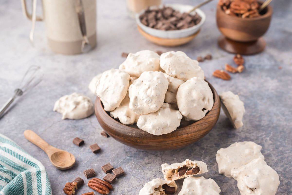 A wooden bowl full of chocolate chip meringue cookies
