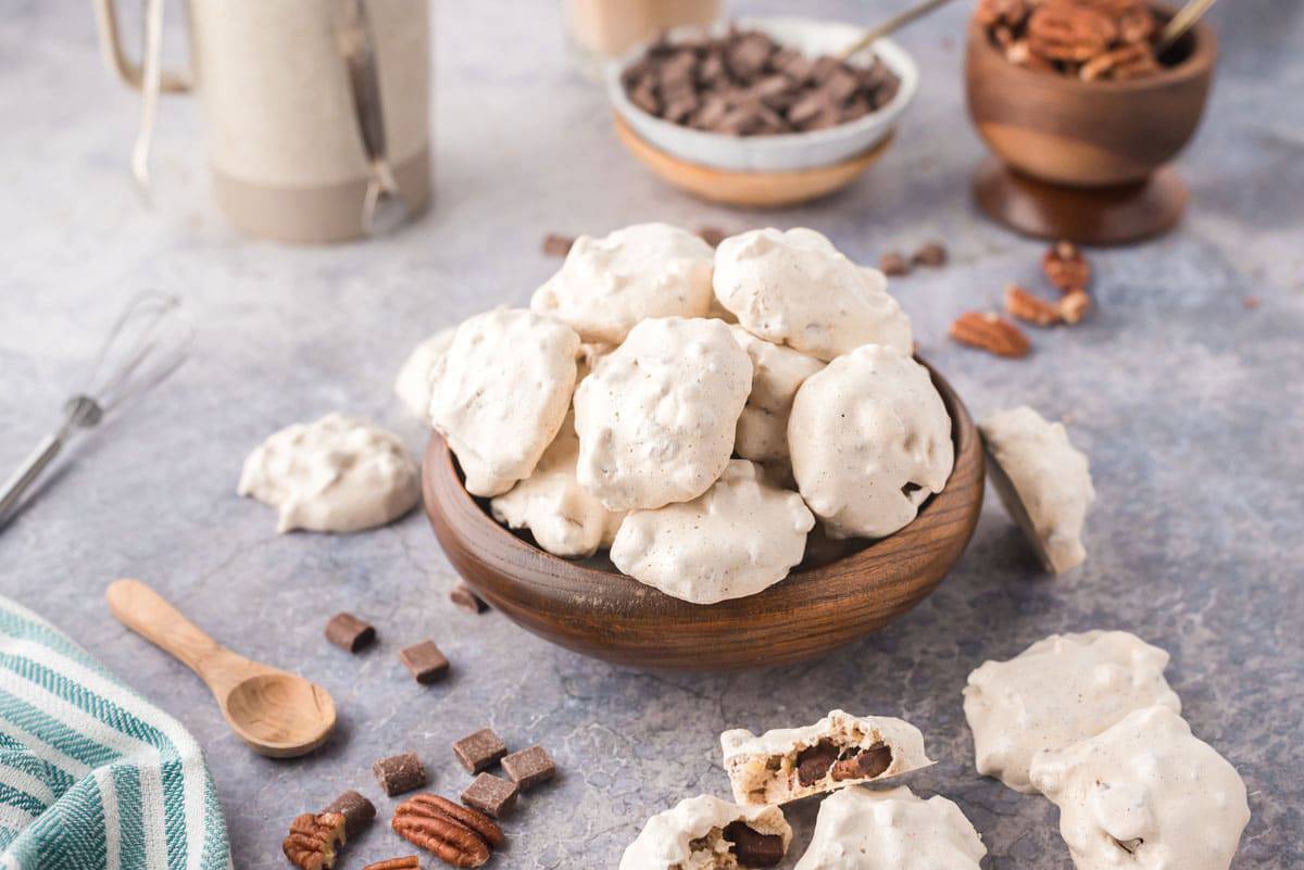 A bowl of chocolate chip meringue cookies A wooden bowl full of chocolate chip meringue cookies