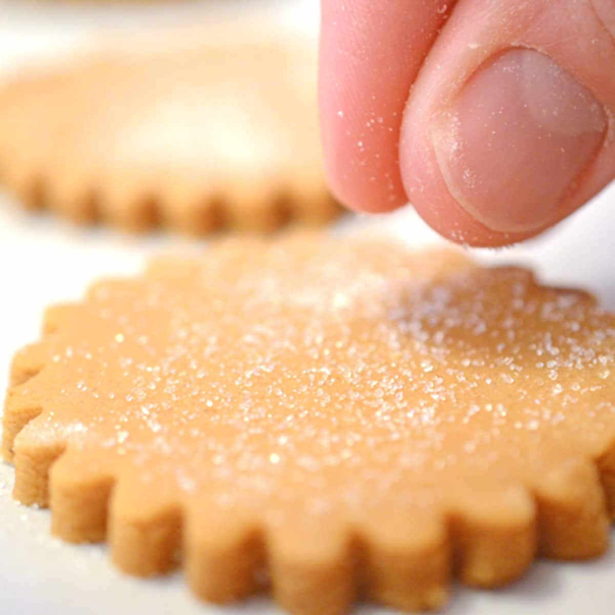 Sprinkling sugar on an unbaked cookie.