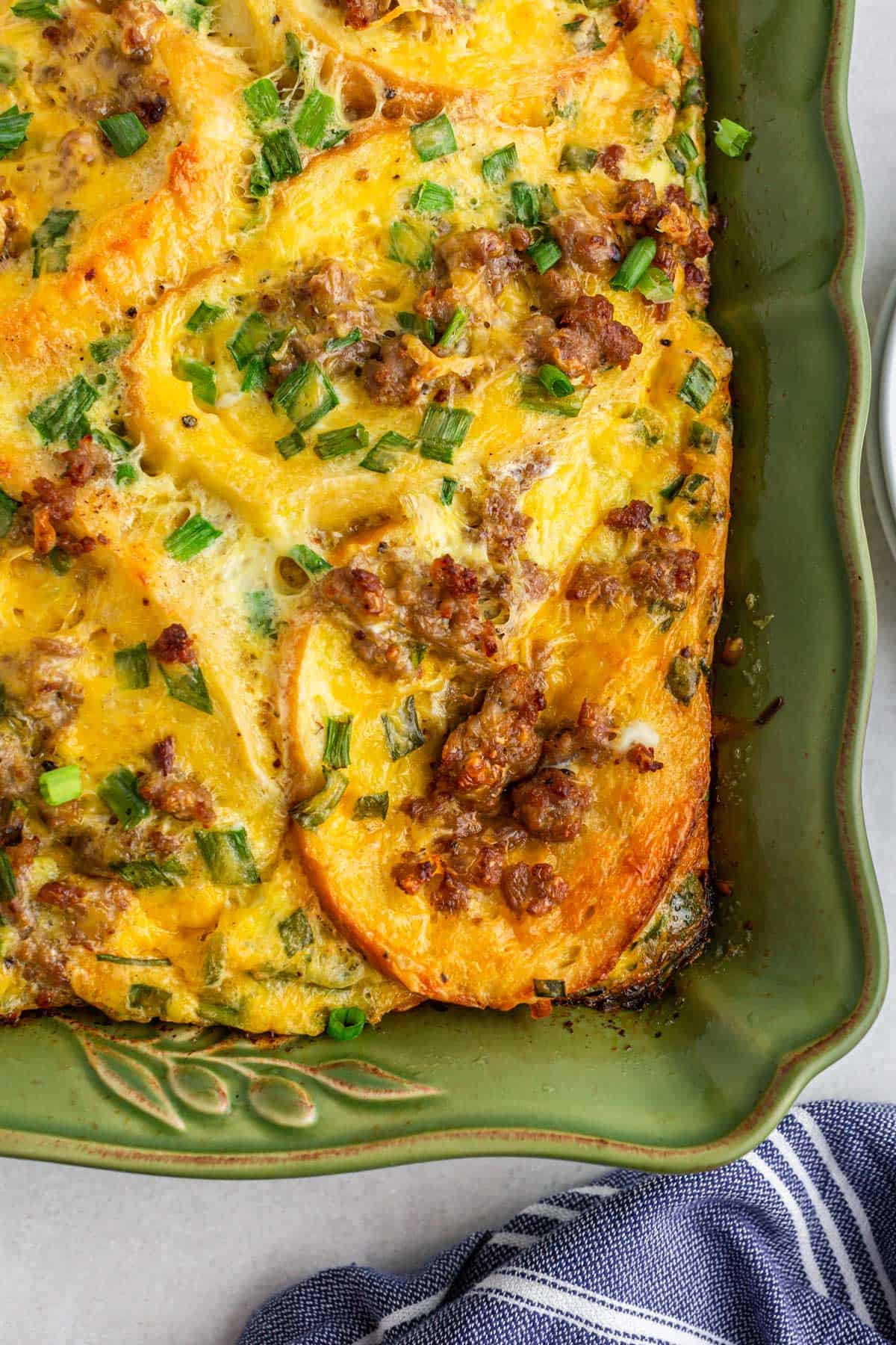 Close-up view of breakfast casserole in a green baking dish.