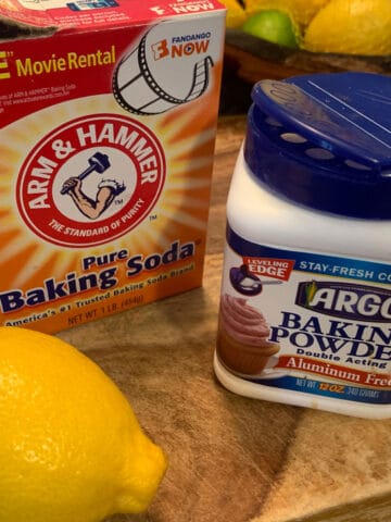 A box of baking soda with some baking powder and a lemon.