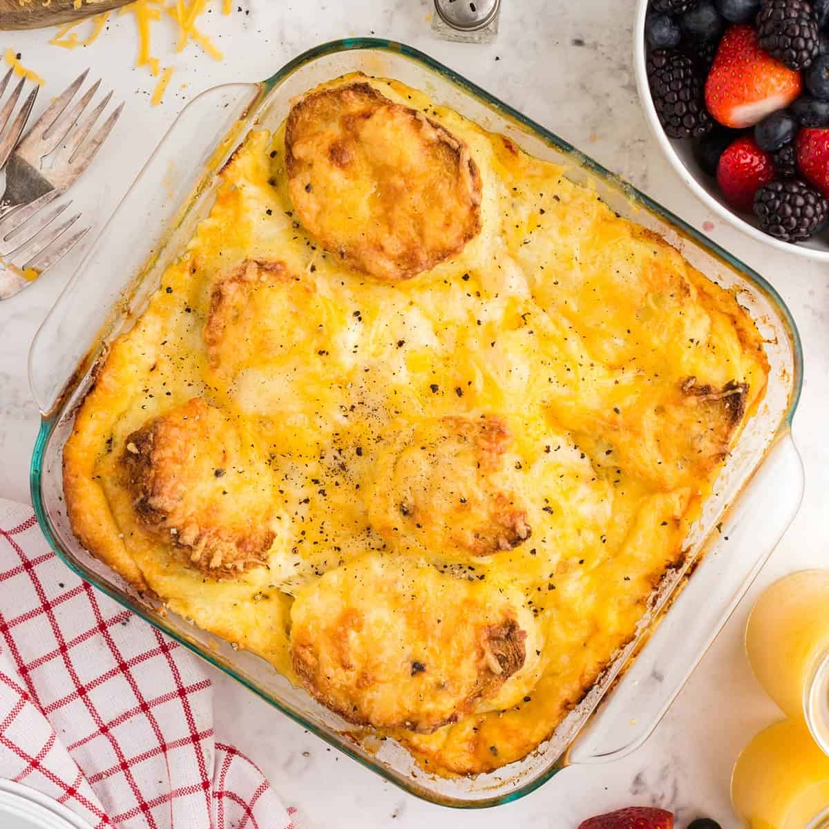 Overhead view of cheese strata with fresh berries on the side.