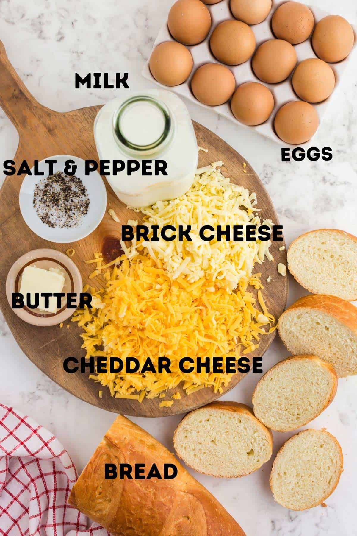 Bread, cheese, eggs, and milk on a cutting board.