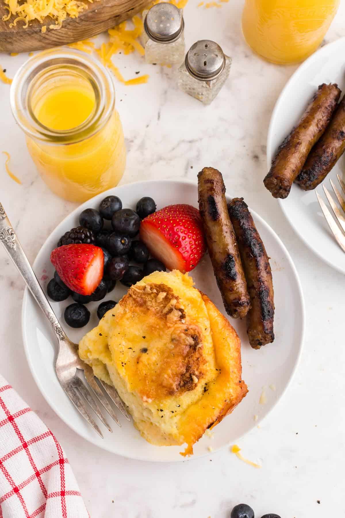 A plate of food with sausage and orange juice.